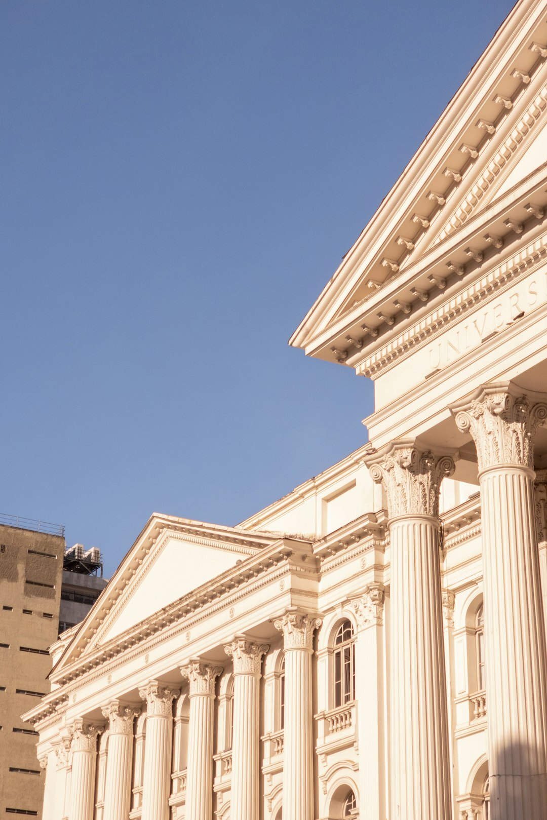 Neoclassical government building facade with columns under a clear sky