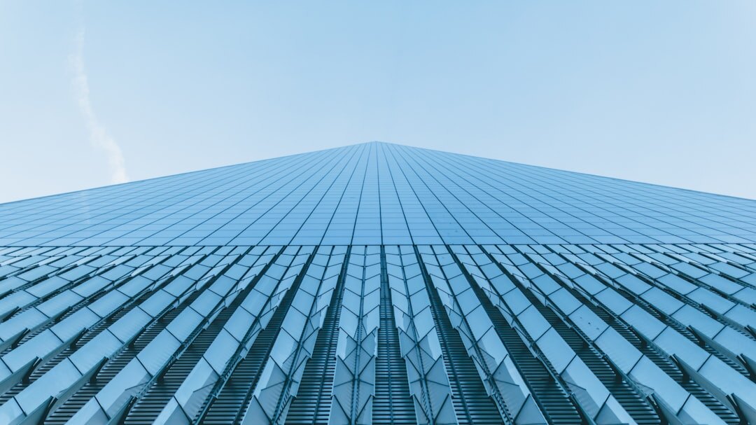 Modern glass corporate office tower seen from below